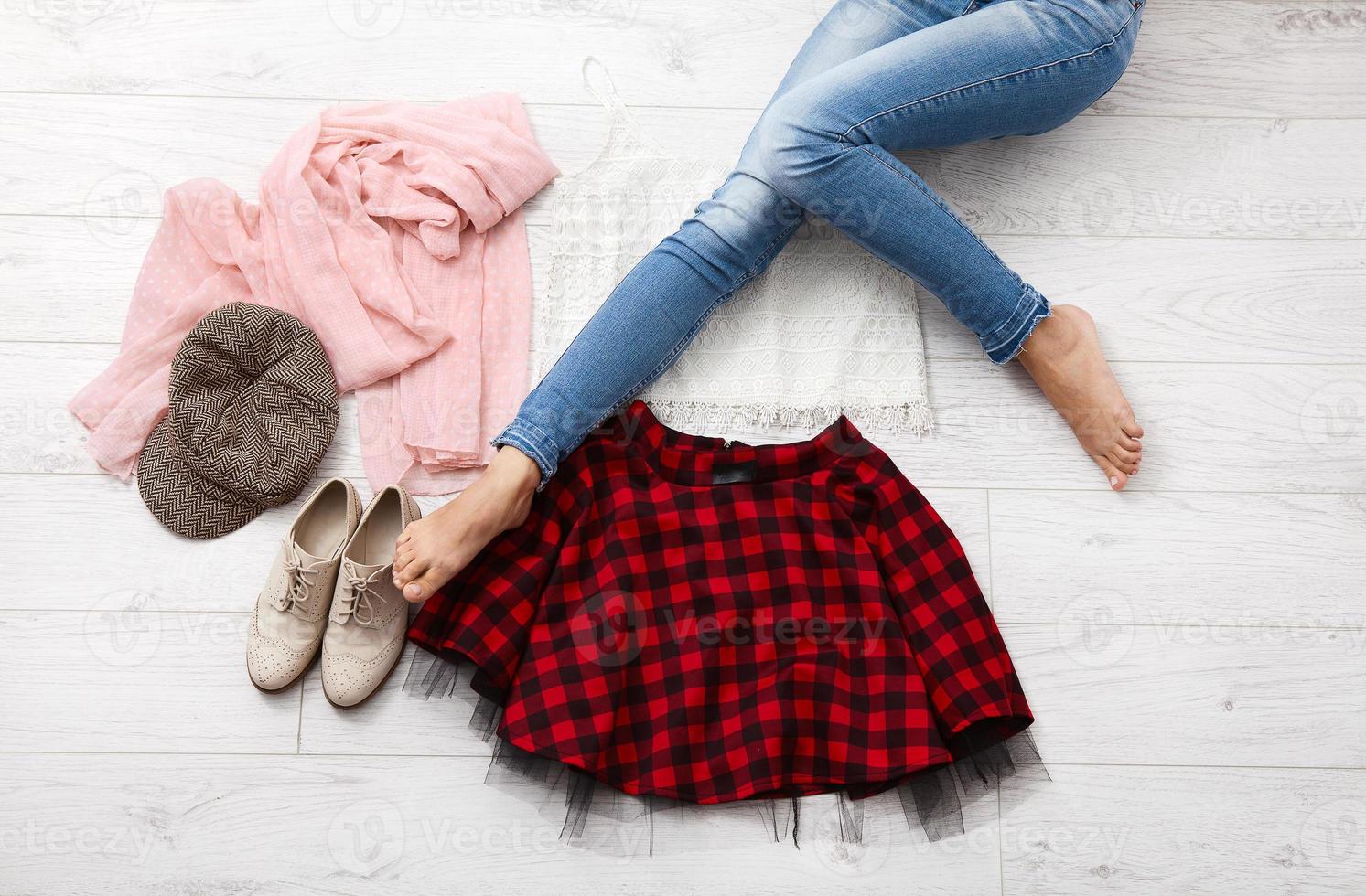 traje elegante y piernas femeninas sobre fondo blanco de madera. vista superior y espacio de copia foto