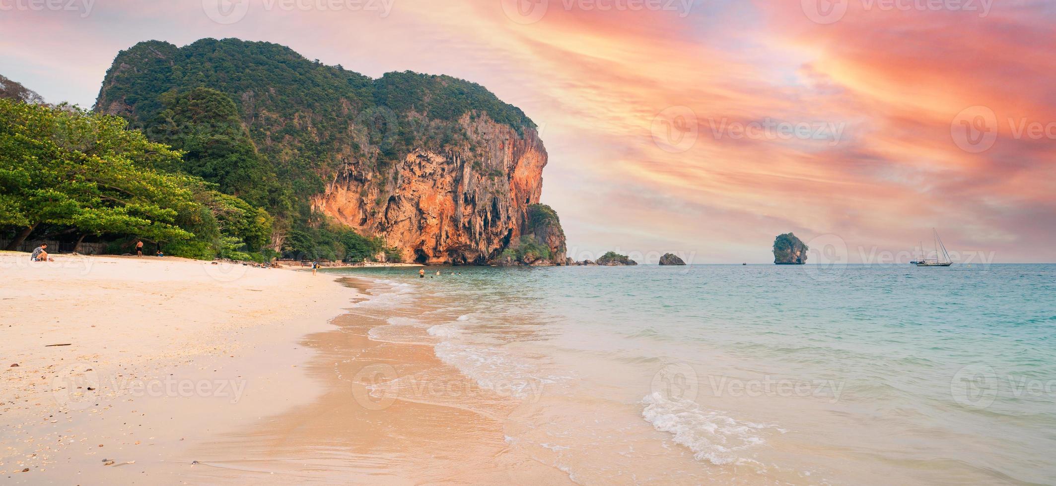 sea, beach and rocky mountains in tropical evening photo