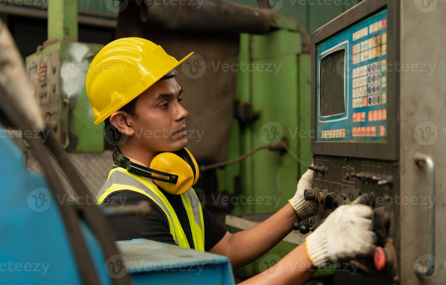 mecánico asiático trabajando en una fábrica mecánica reparando máquinas antiguas foto