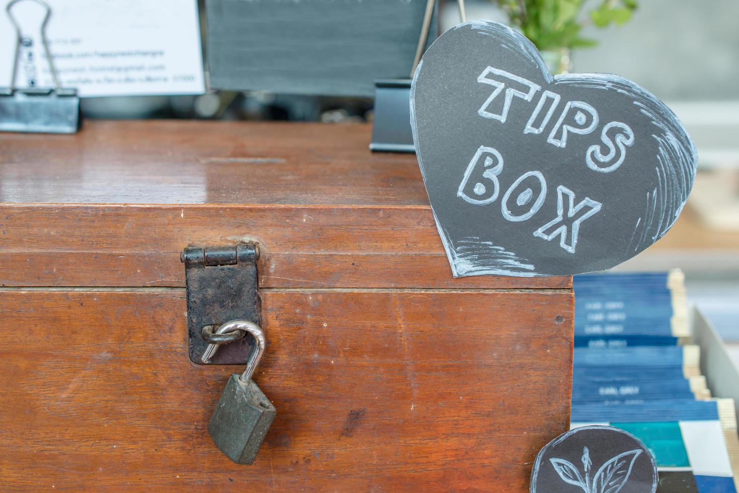 la caja de consejos para un buen servicio en el restaurante. Las propinas son una suma de dinero que un cliente o cliente suele dar a un trabajador del servicio, además del precio básico. foto