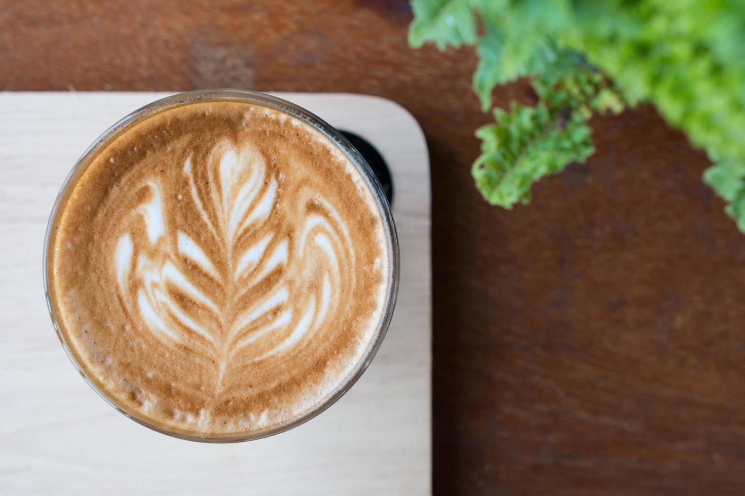 A cup of hot coffee with latte art on the surface. photo