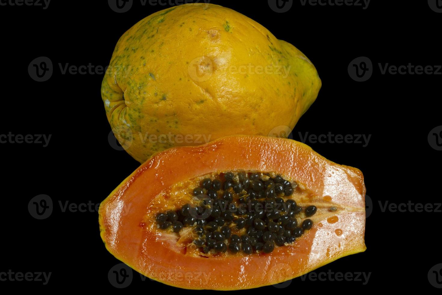 Half Cut of Fresh Ripe Papaya with seeds isolated on dark background. Selective focus. photo