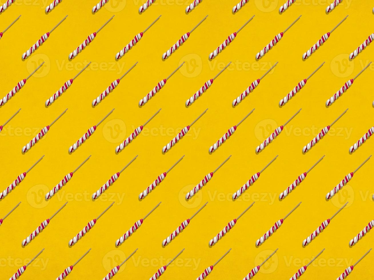 Lollipops in rows on yellow background photo