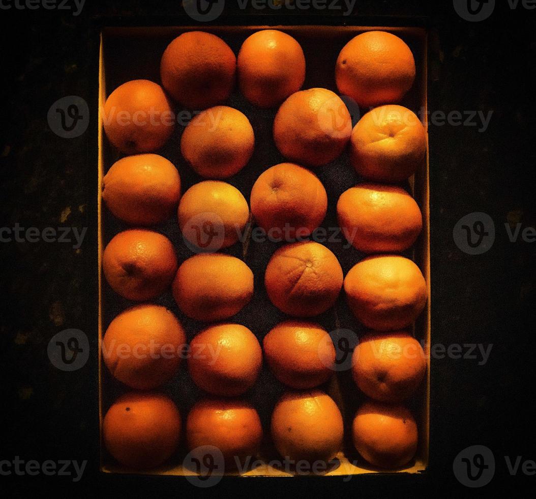 Multiple oranges ordered precisely on a dark balcony photo