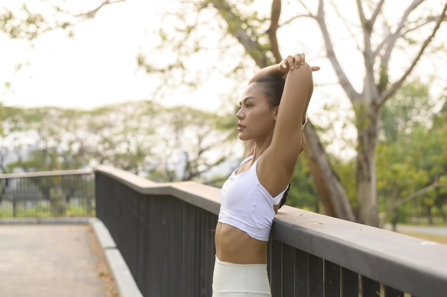 A young fitness woman in sportswear exercising in city park, Healthy and Lifestyles. photo