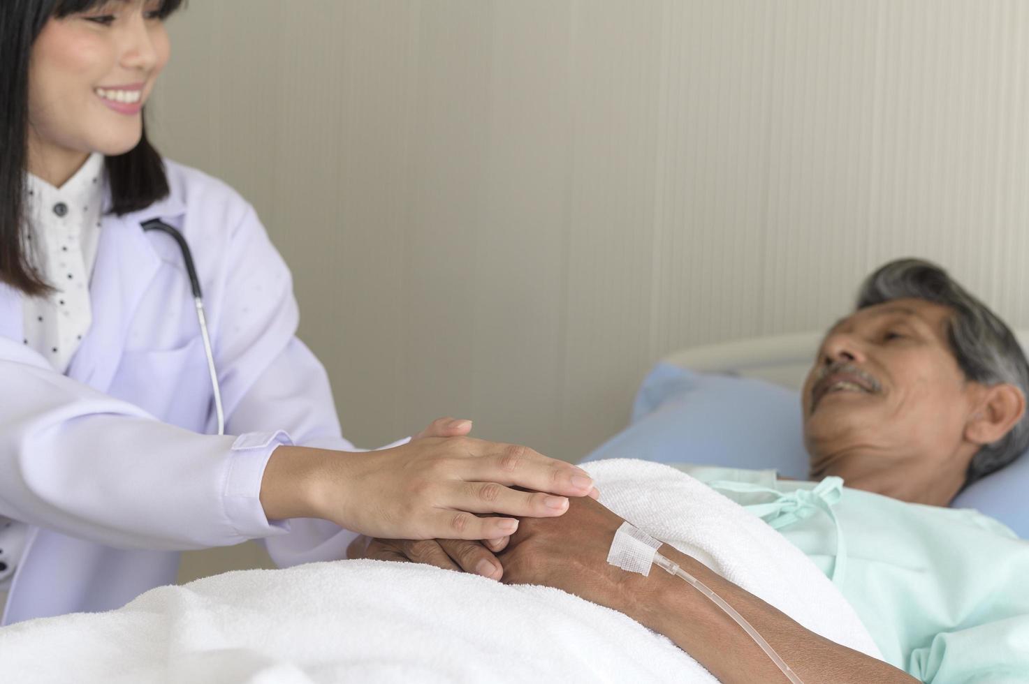 médico sosteniendo la mano del paciente mayor en el hospital, atención médica y concepto médico foto