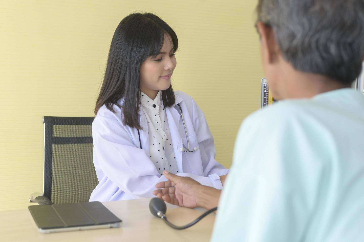 Asian senior male patient is consulting and visiting doctor in hospital.. photo