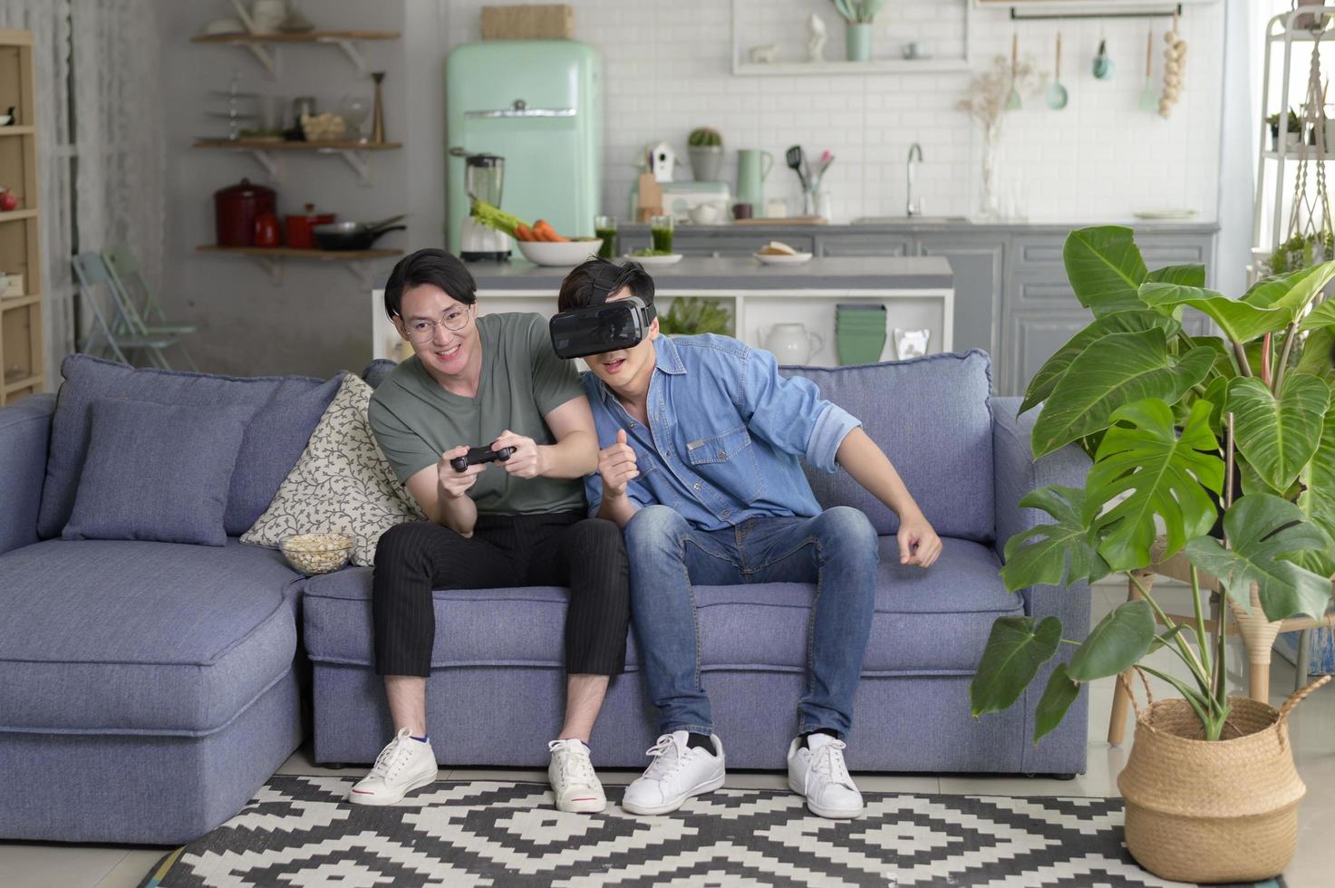 joven pareja gay sonriente jugando videojuegos en la sala de estar en casa, lgbtq y diversidad foto