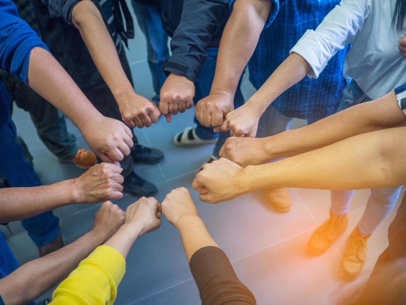 Close-up of many people putting their fists together as symbol of unity photo