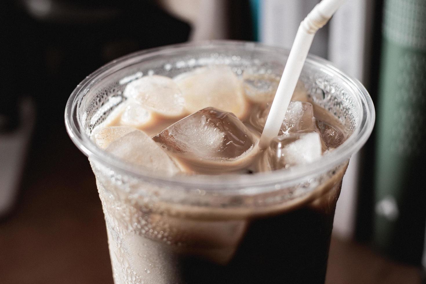 Close up iced coffee in plastic glass and white tube photo