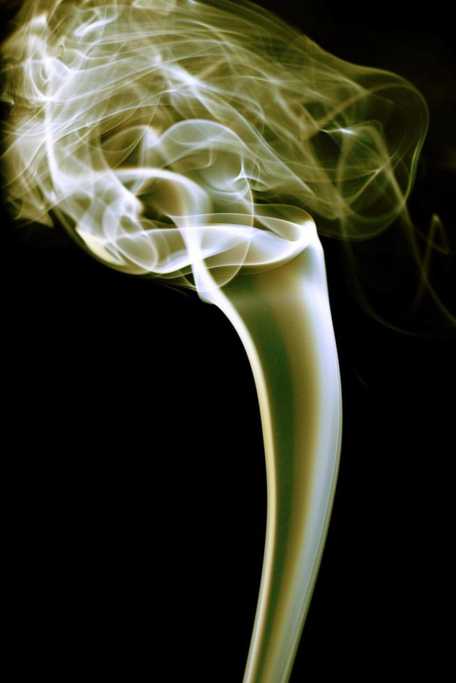 Yellow smoke on black background photo