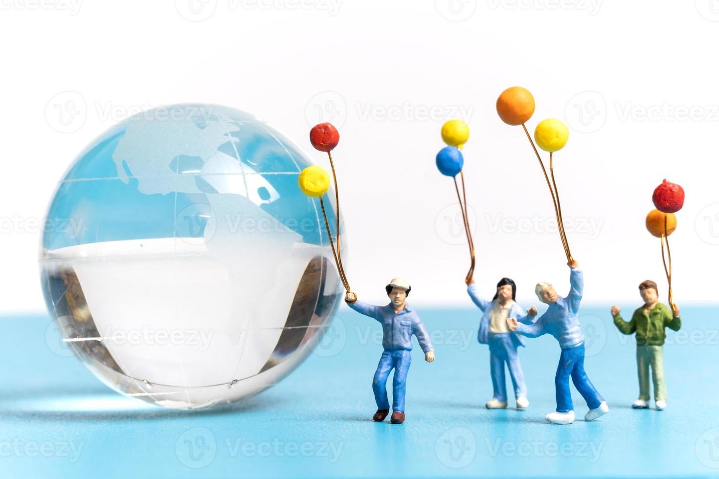 Miniature people kid holding balloon with crystal Globe photo