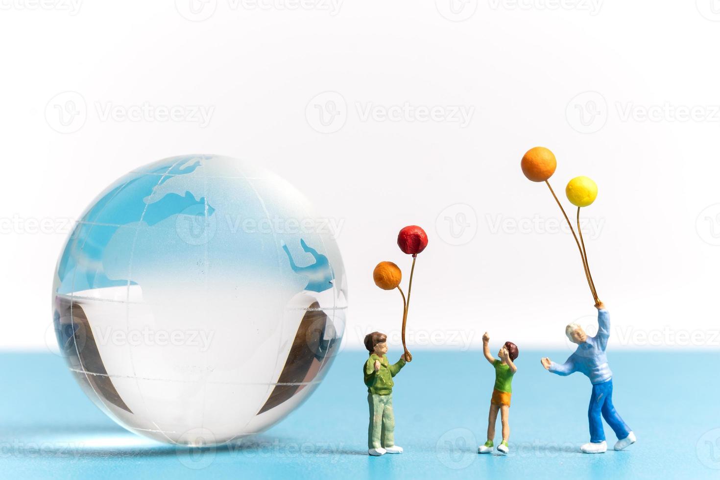 Miniature people kid holding balloon with crystal Globe photo