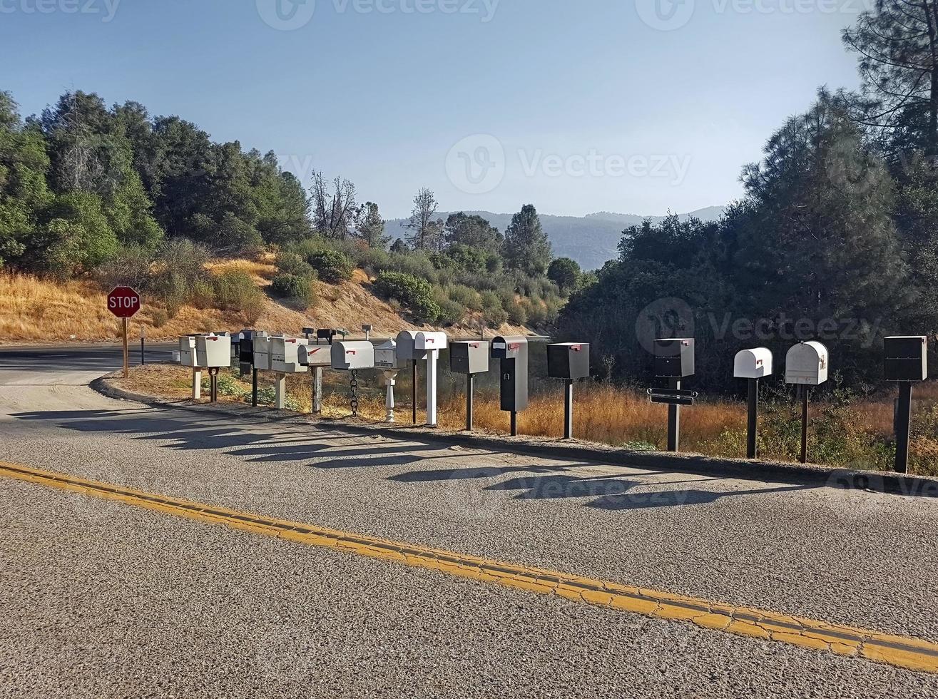 American road with numerous mailboxes placed one after the other and with the shadow reflected in the asphalt of the city road photo