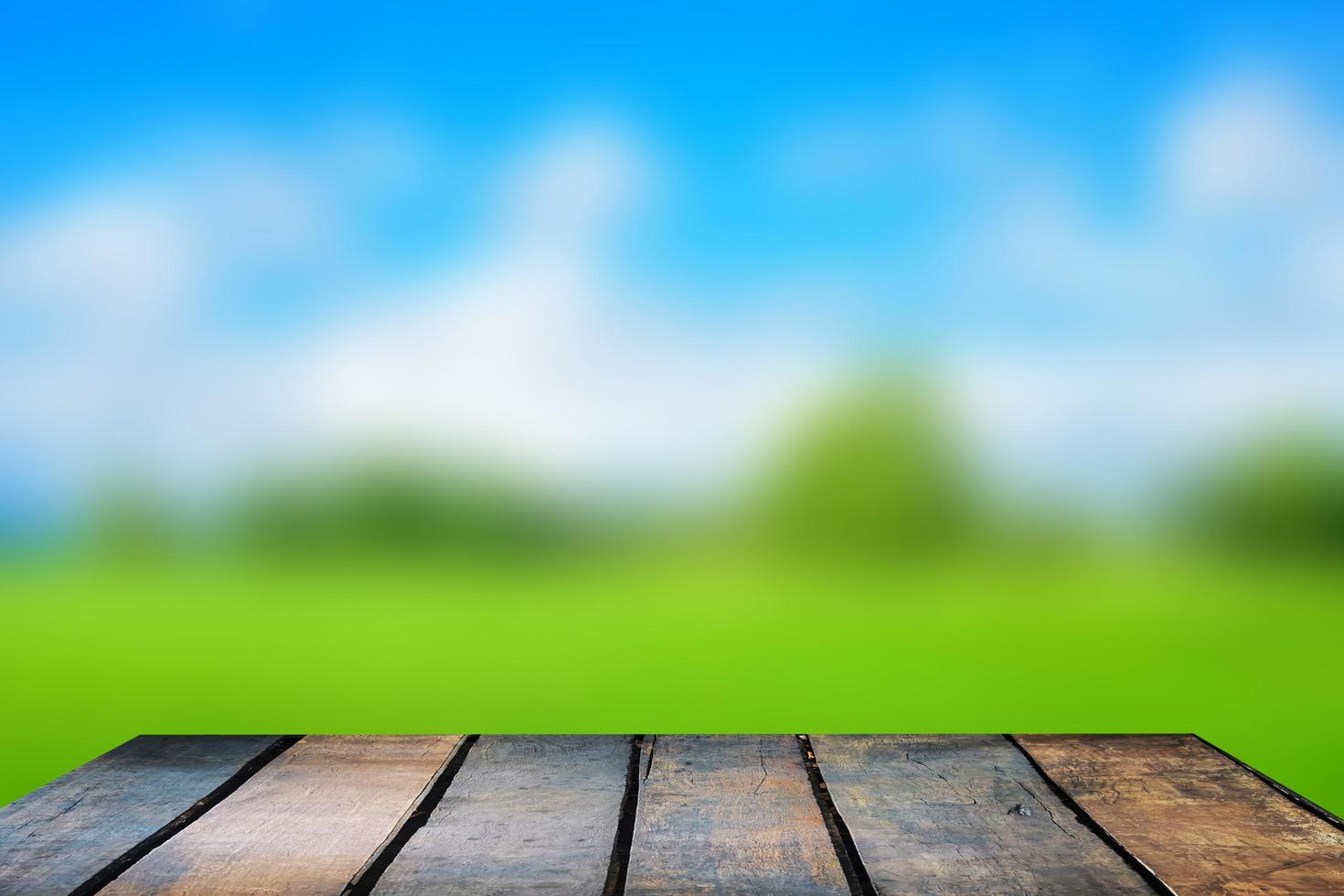 Wooden table and blur of beauty on sunny day on rice field with sky and mountains as background. photo