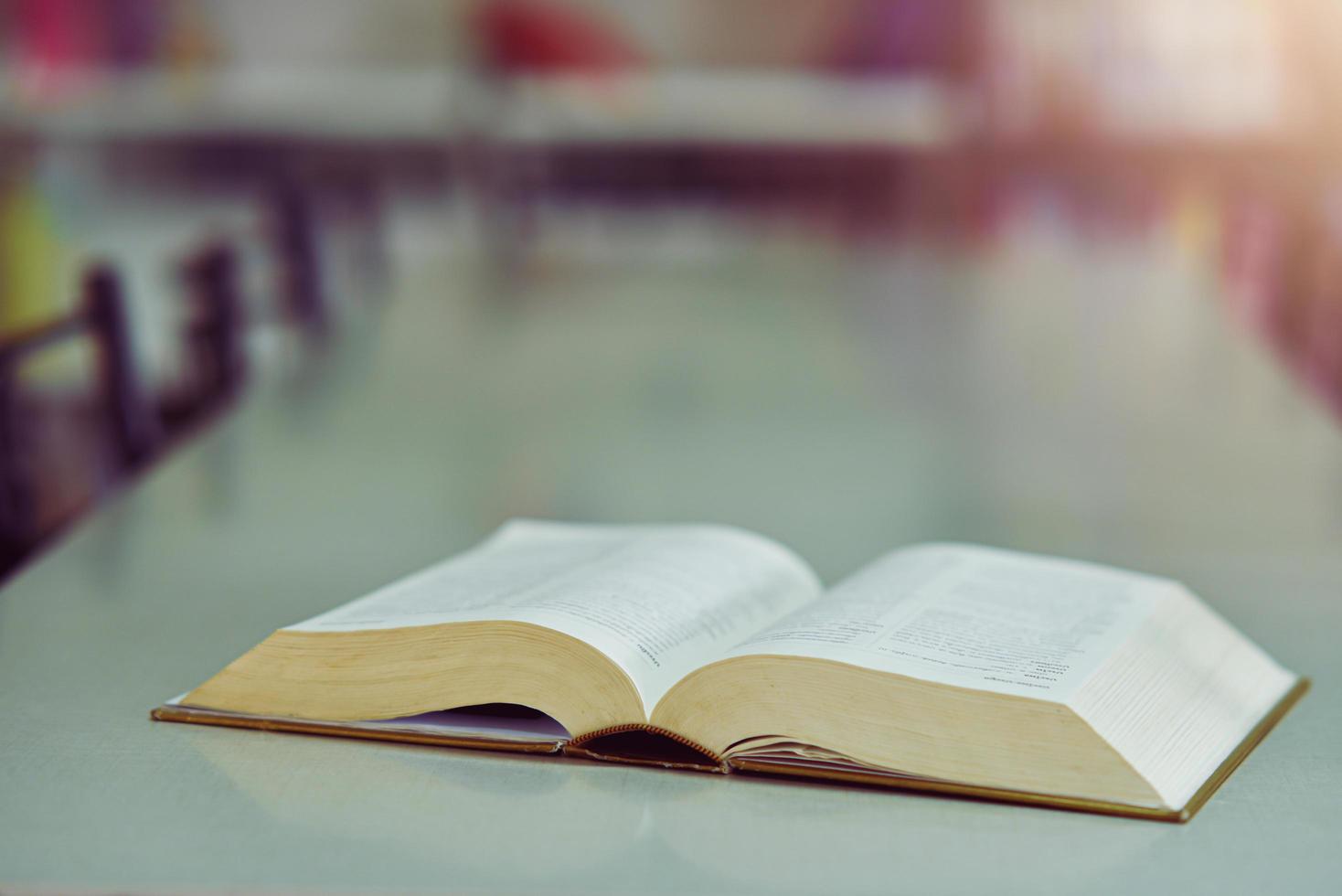 Open book on the table in library photo