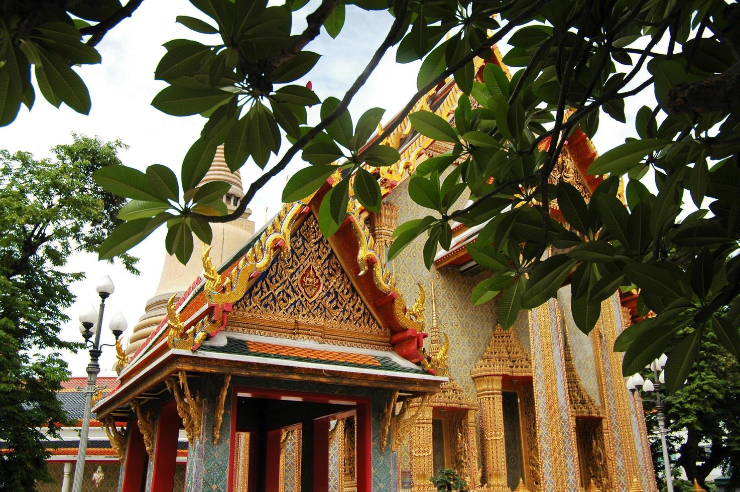 Thai golden temple through trees shade photo