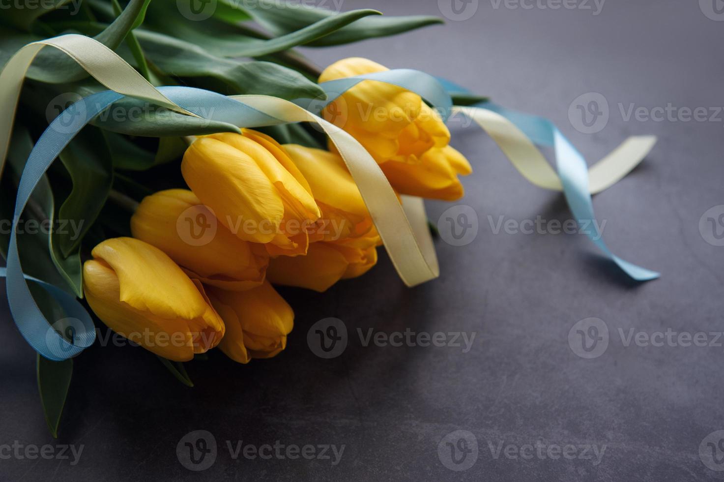 Bouquet of tulips with blue and yellow ribbon photo