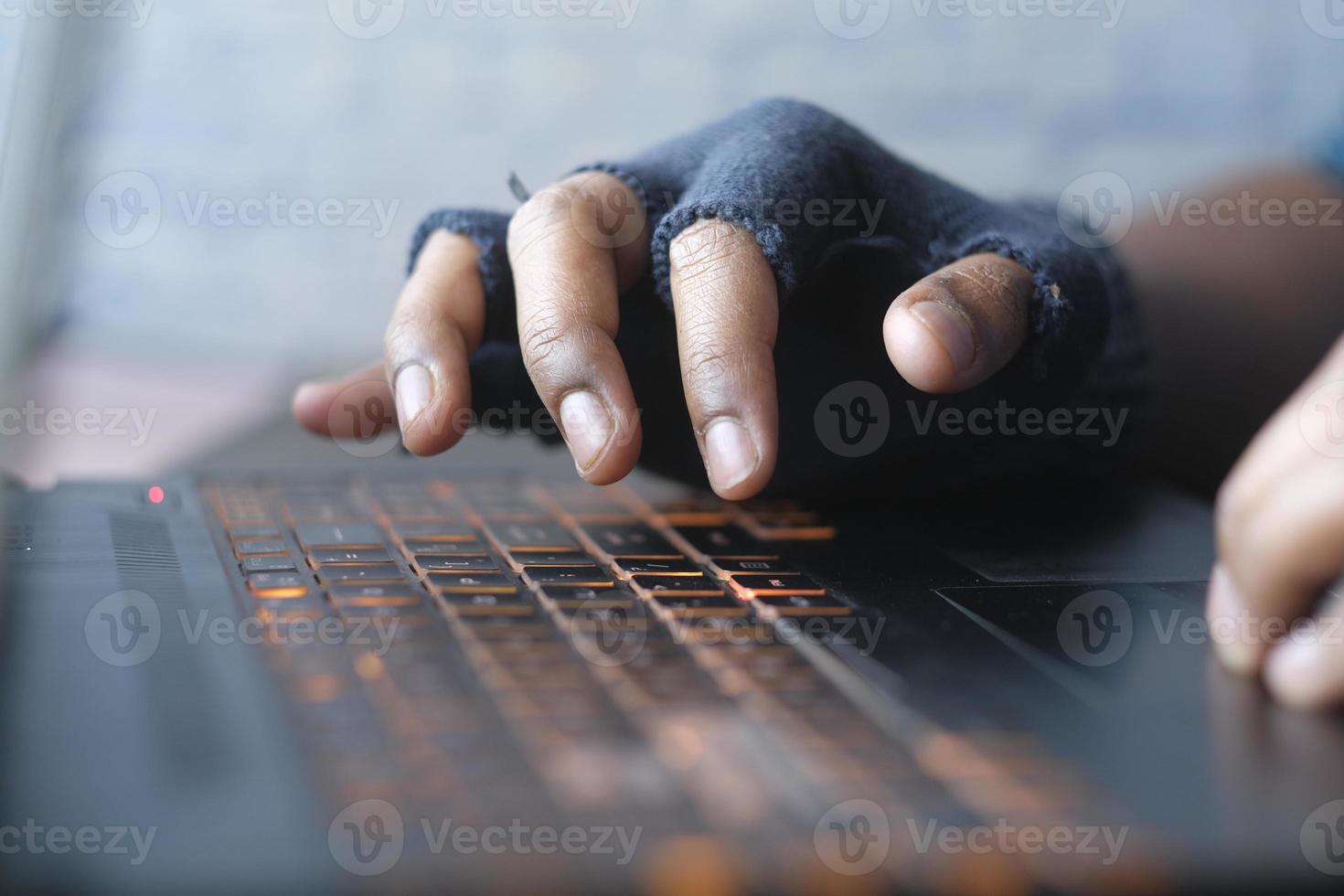 hacker hand stealing data from laptop top down photo