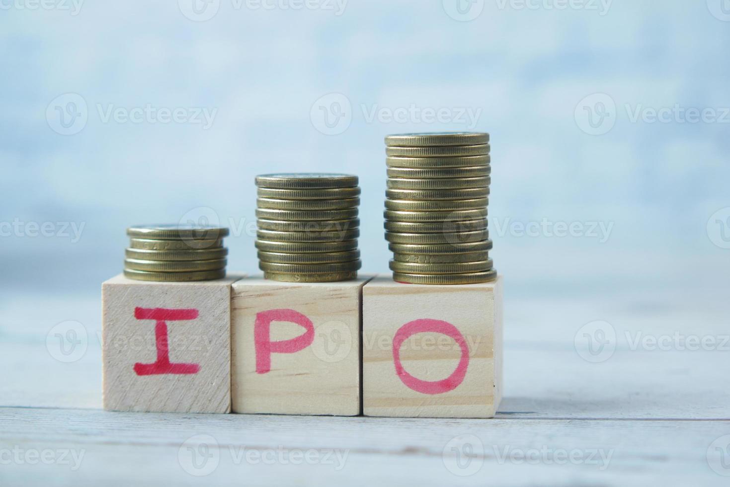 IPO text ,Initial Public Offering on wooden block with stack of coins photo