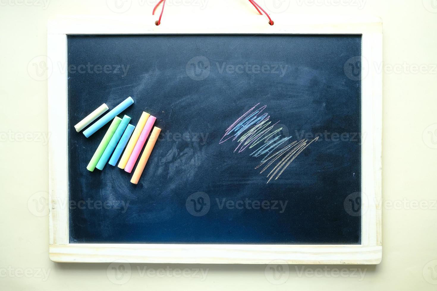 colorful chalk and chalkboard on black background photo
