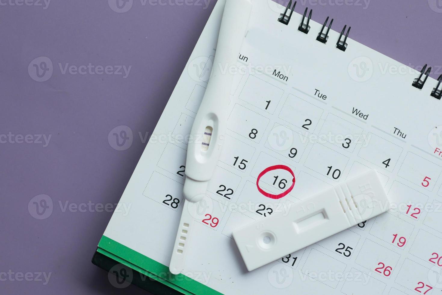 Pregnancy test kit on a calendar close up photo