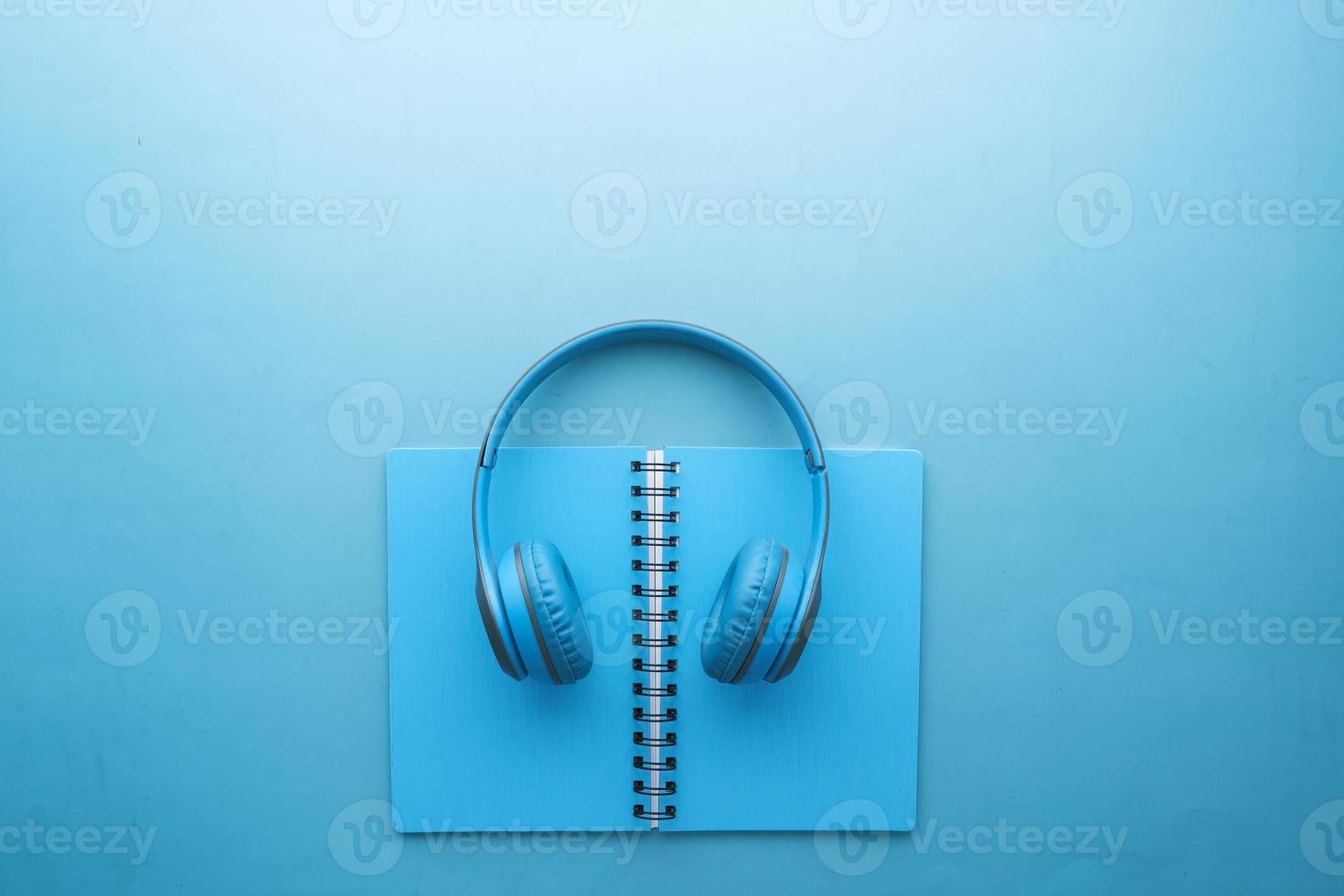 Audio book concept. Headphones and notepad on white background photo