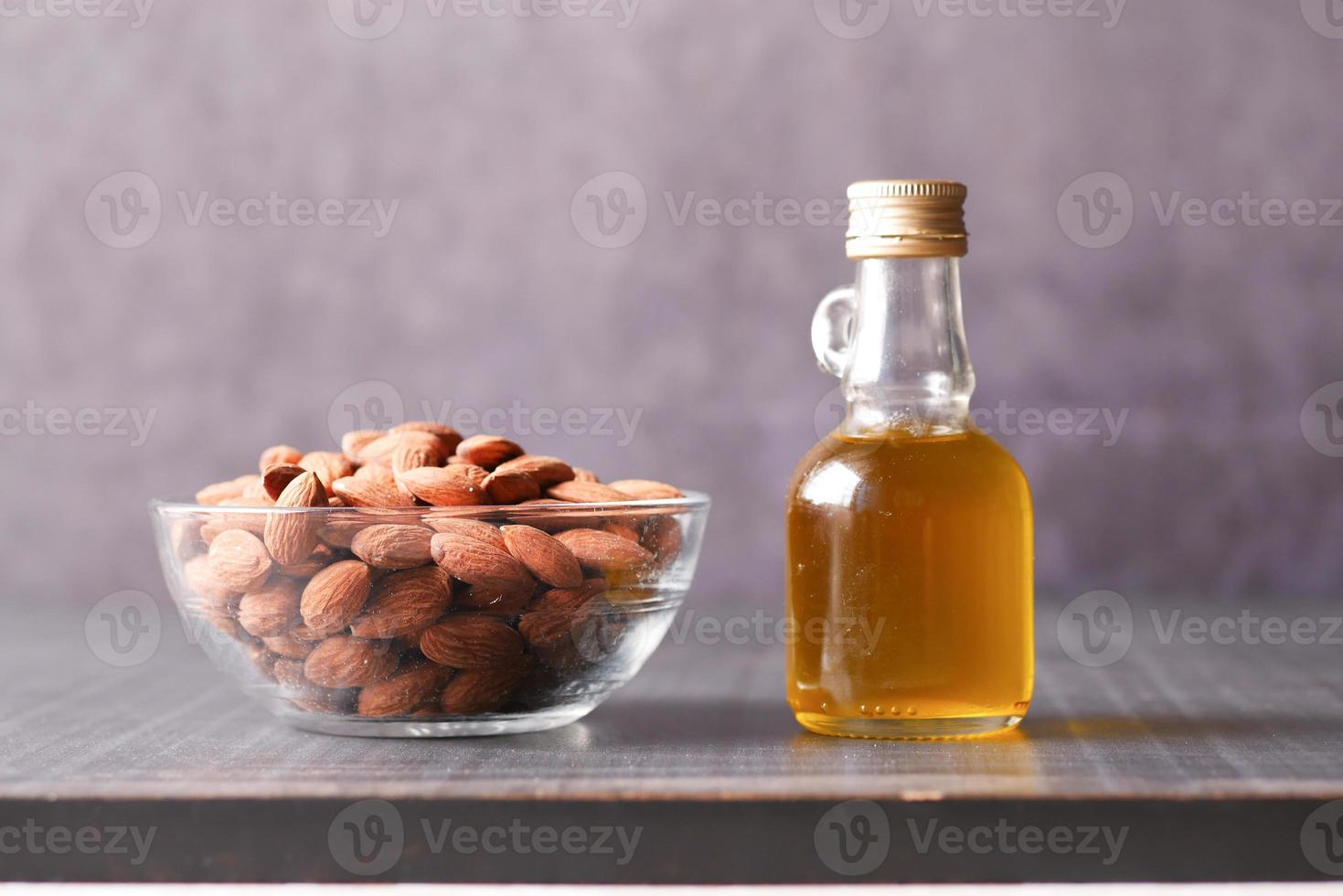 almond oils and fresh nuts on black background photo