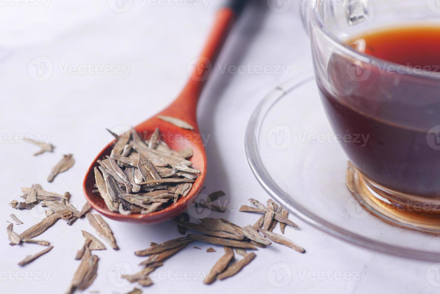 Dry tea leaves on spoon close up . photo