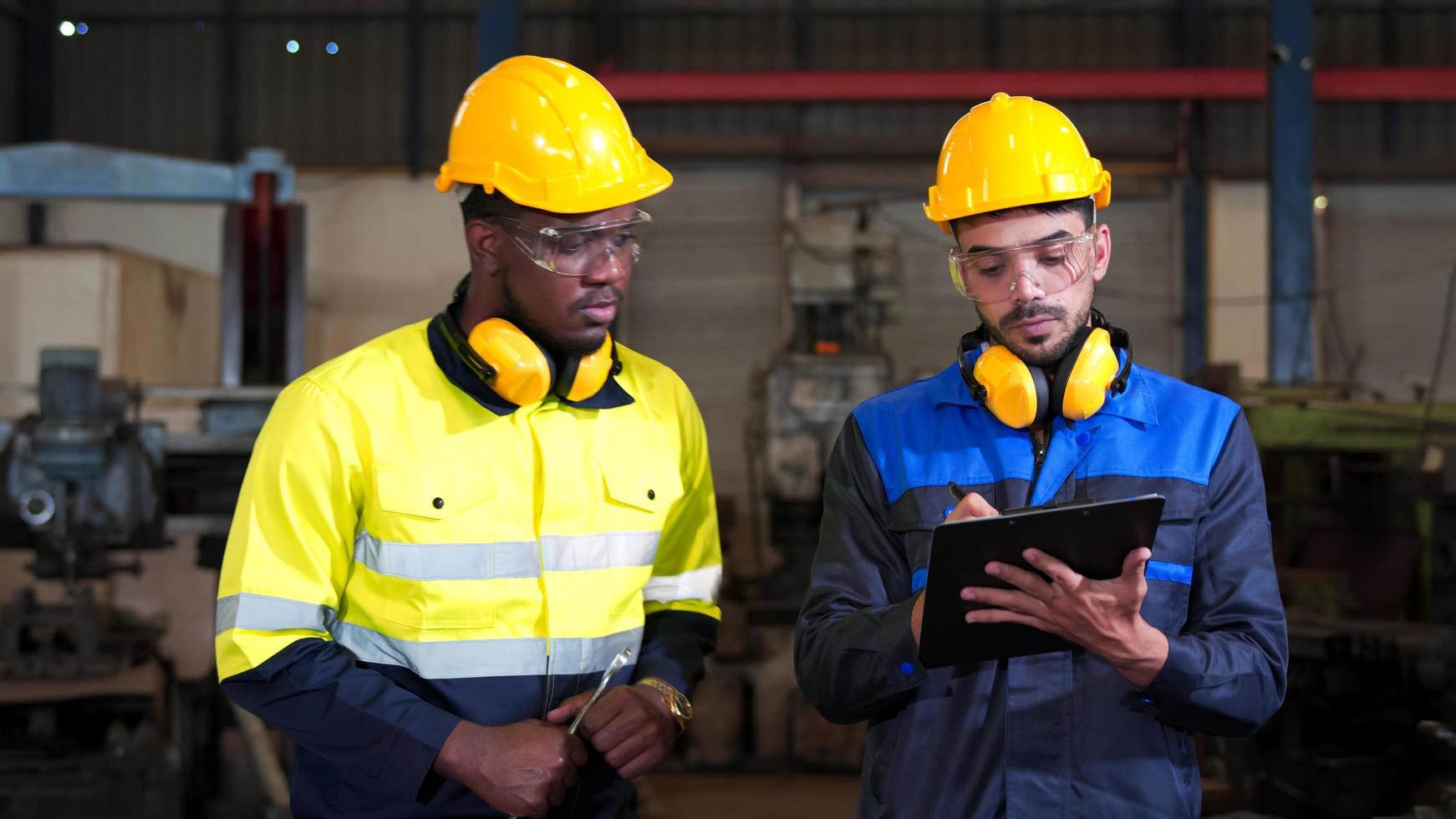 diversidad, colega del ingeniero de equipo pesado de la industria. inspección profesional, técnico, trabajador con uniforme de seguridad, casco, casco mientras revisa la fábrica de producción de la línea de máquinas de mantenimiento. foto