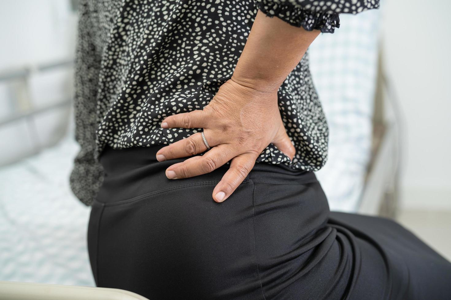 Asian lady patient wearing back pain support belt for orthopedic lumbar with walker. photo