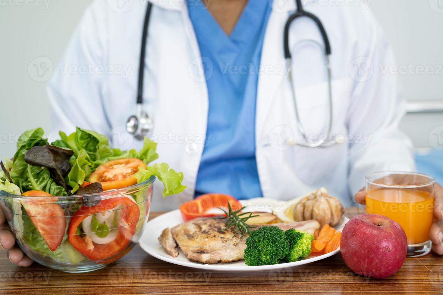 Nutritionist doctor with various healthy fresh vegetables for patient. photo