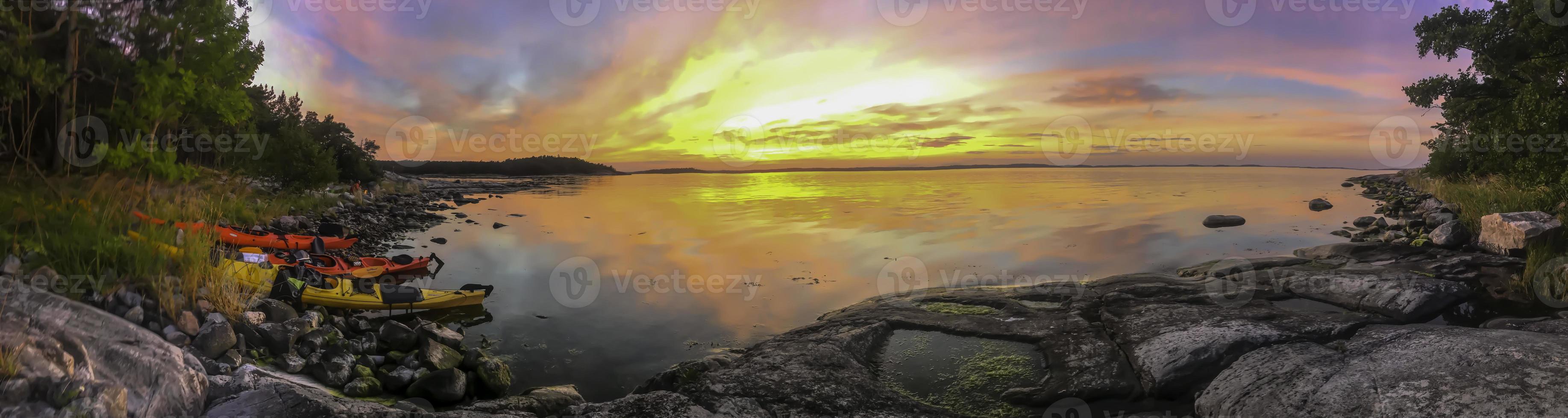 Kayaks campsite by a sunset Swedish lake in summer photo