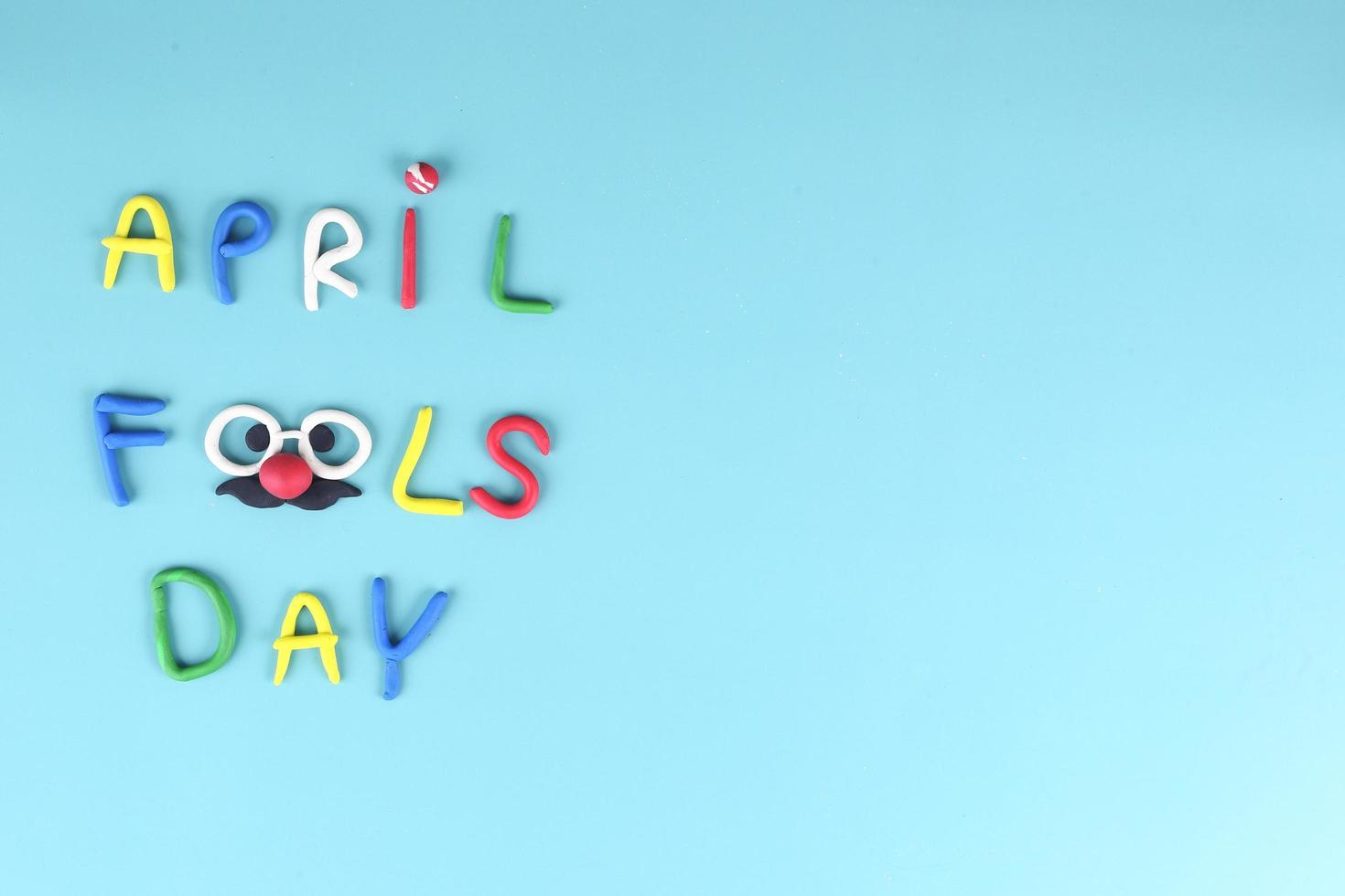 Top view of april fool day background - crayon word on blue background photo
