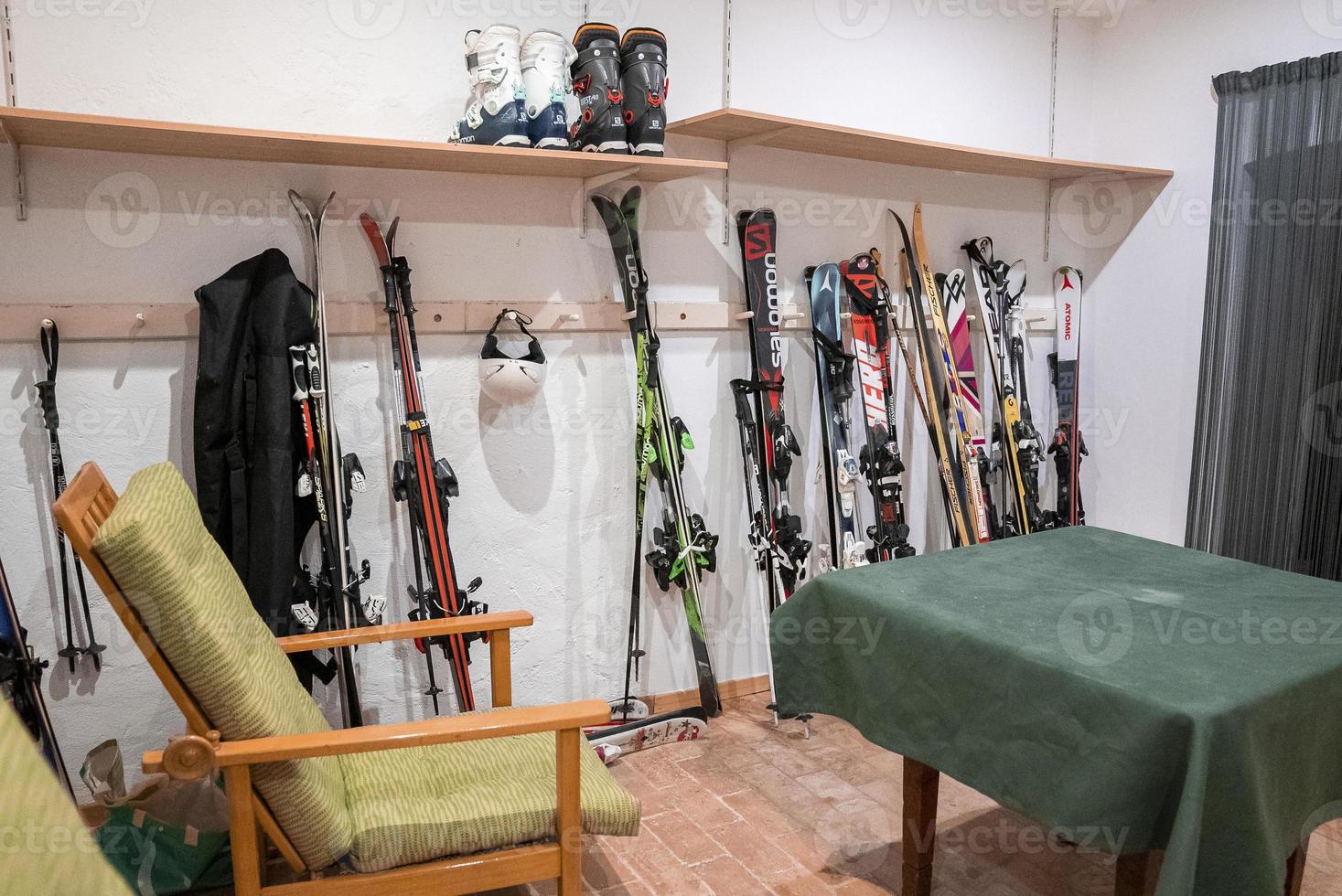 Assortment of colorful skis standing against wall in room at winter chalet photo