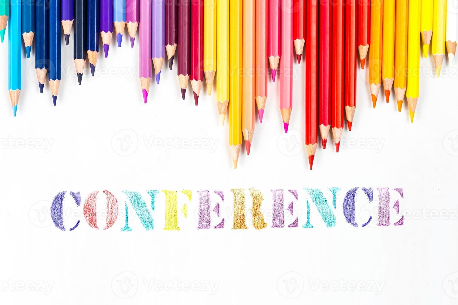 Multi-colored wooden sticks Wooden colouring pencils and Conference on white background photo