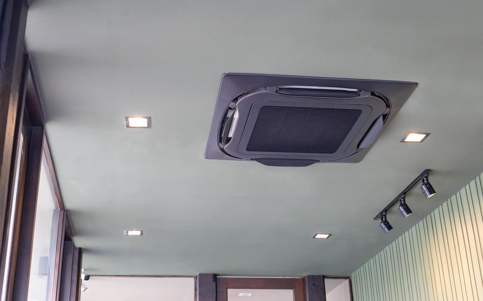 moderno sistema de aire acondicionado tipo casete montado en el techo en una cafetería foto