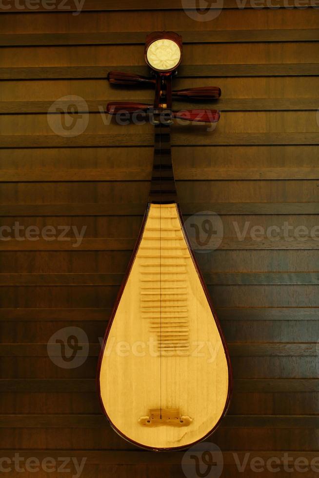 A pipa hanging on a wall. It is a four-stringed Chinese musical instrument. photo