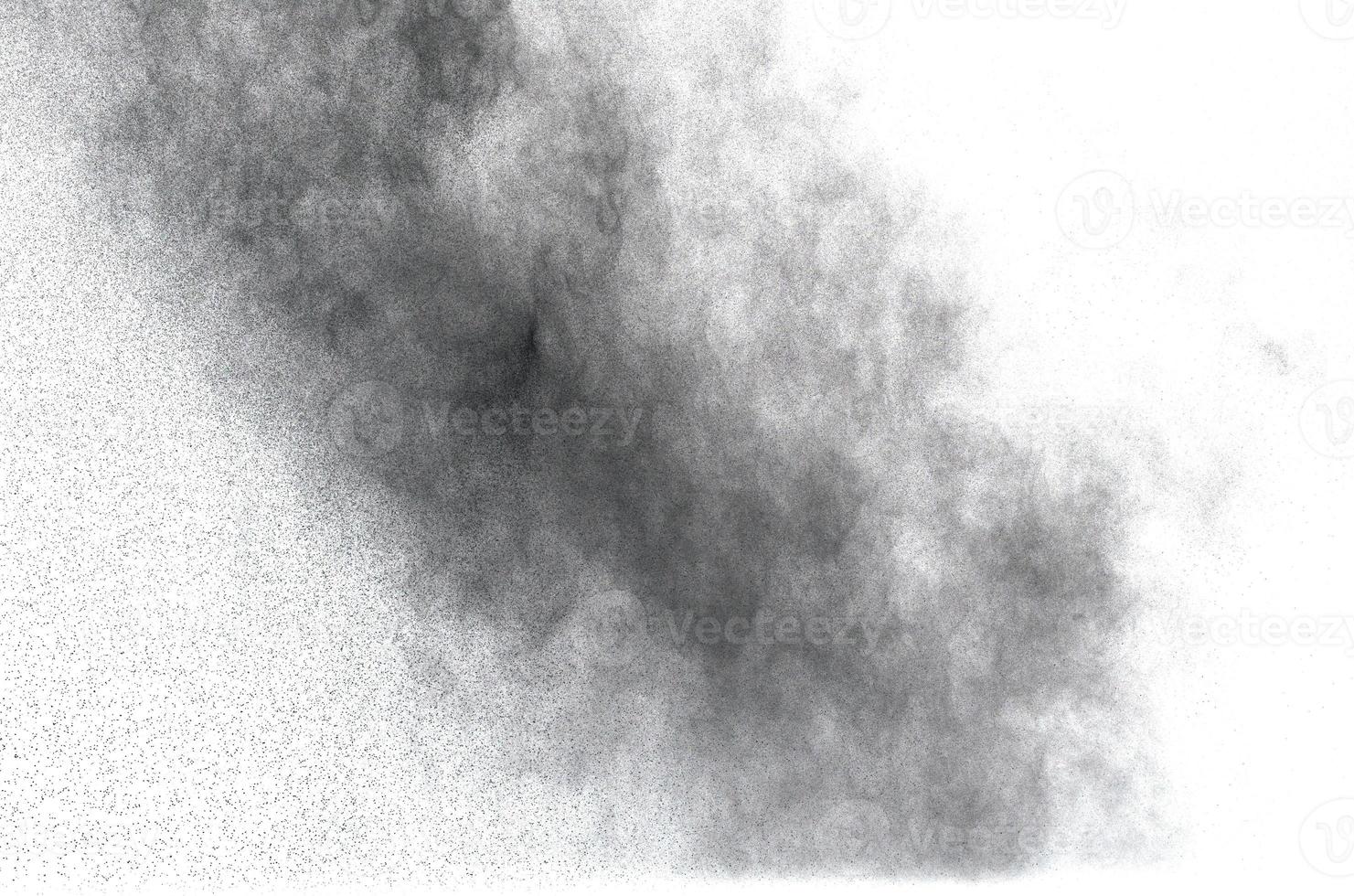 explosión de polvo negro sobre fondo blanco. salpicadura de partículas de polvo negro. foto