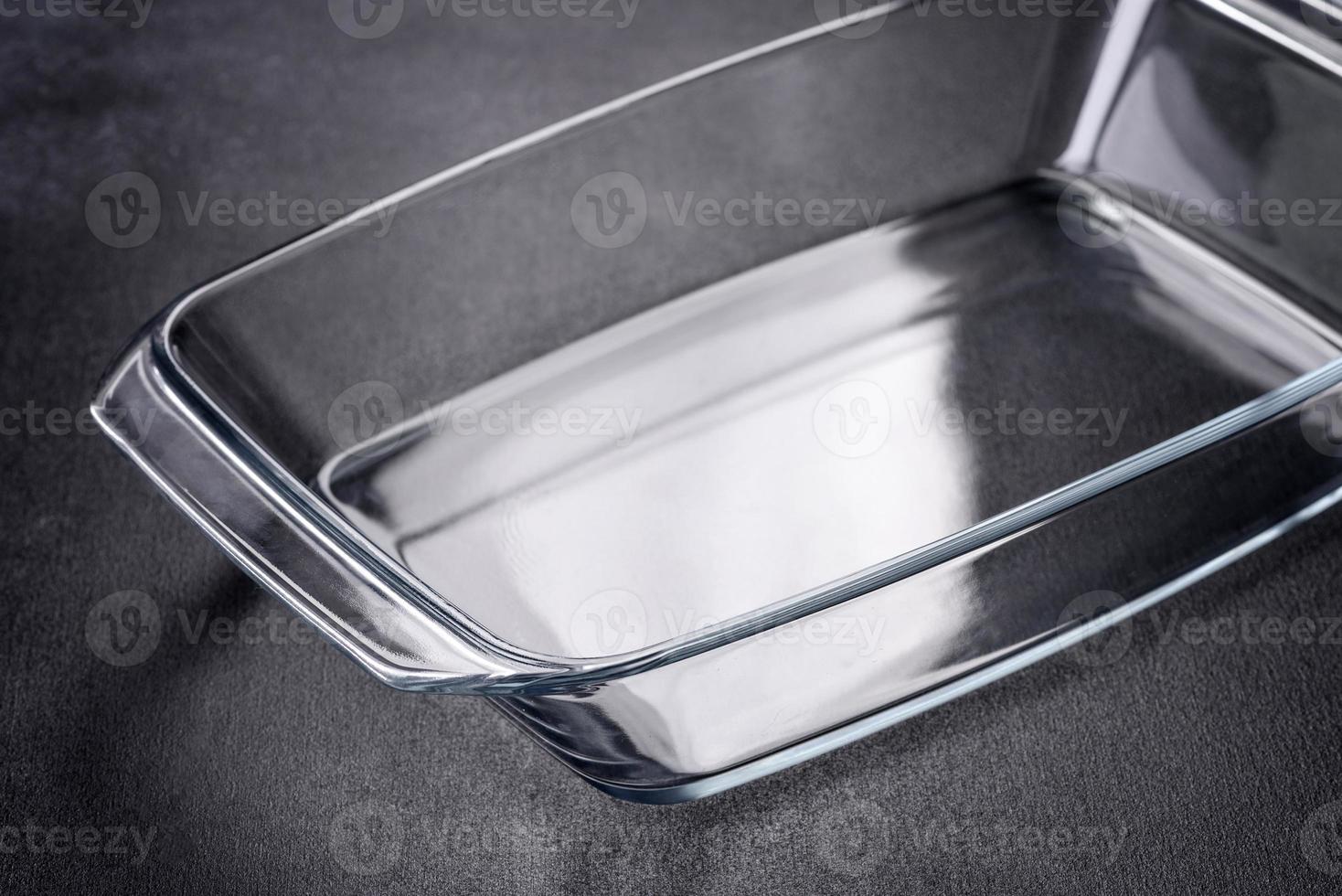 un plato vacío de vidrio rectangular para hornear sobre un fondo de hormigón oscuro foto