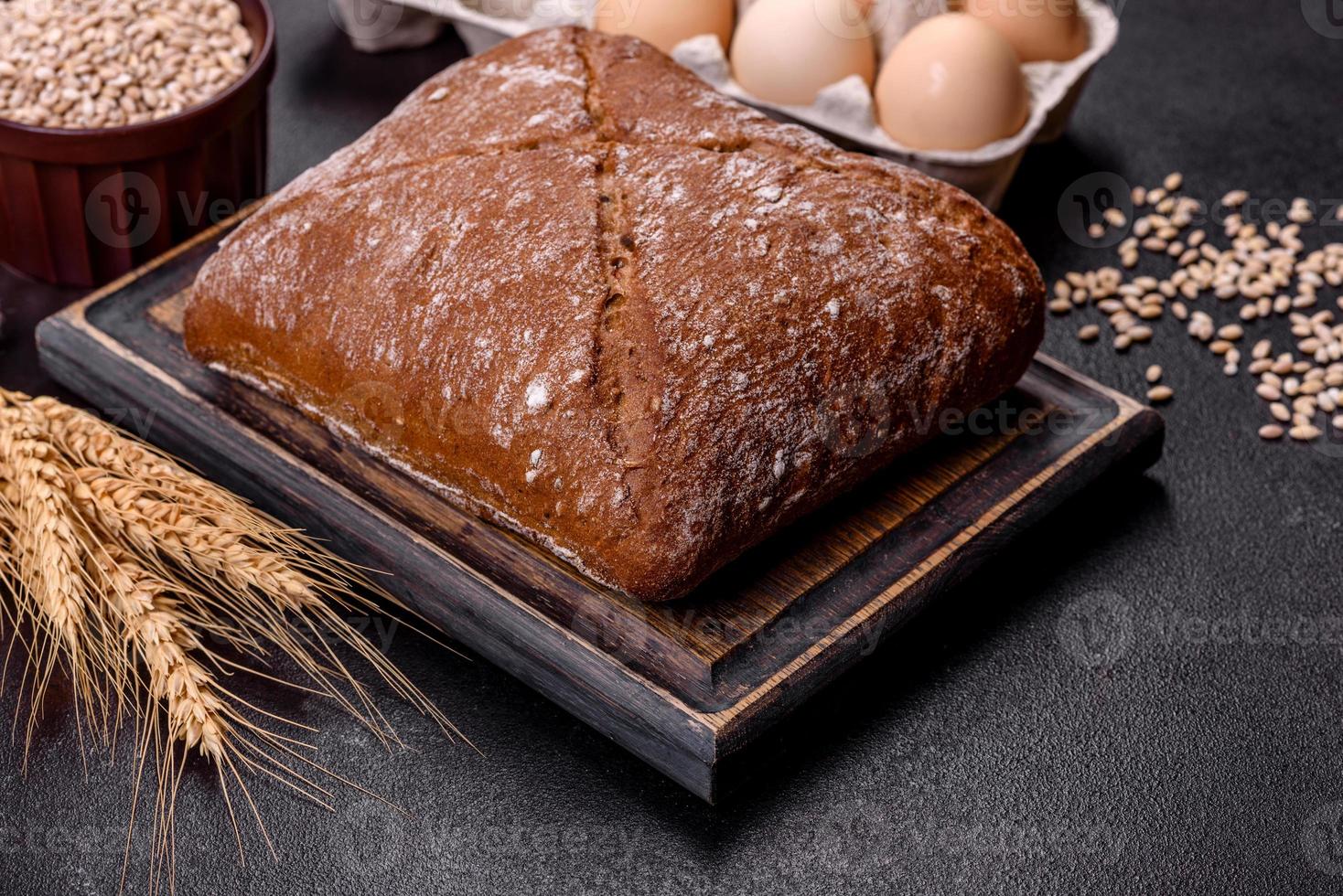 Beautiful tasty, square-shaped brown bread on a dark concrete background photo