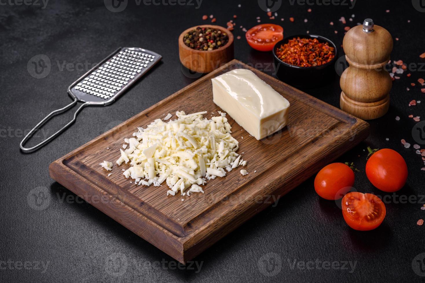 Image of a bar and grated mozzarella cheese on a dark background photo