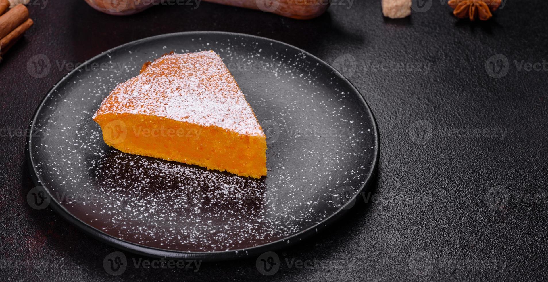 Pumpkin pie, tart made for Thanksgiving day with whipped cream on a black plate photo