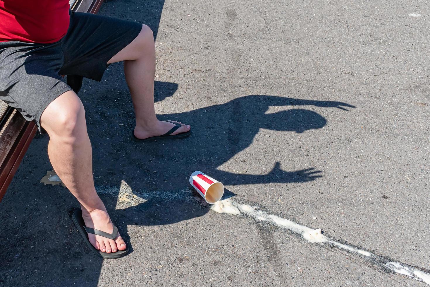 Spilled glass of coffee under teenager's feet photo