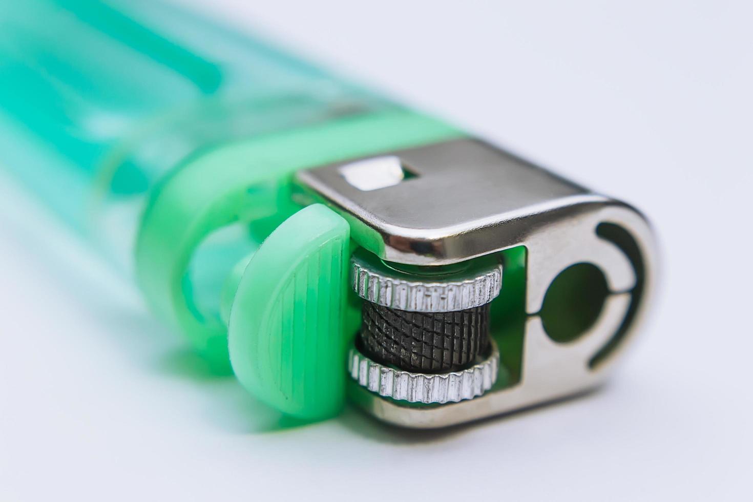 Plain green pocket lighter filled with gas or petrol on a light background photo