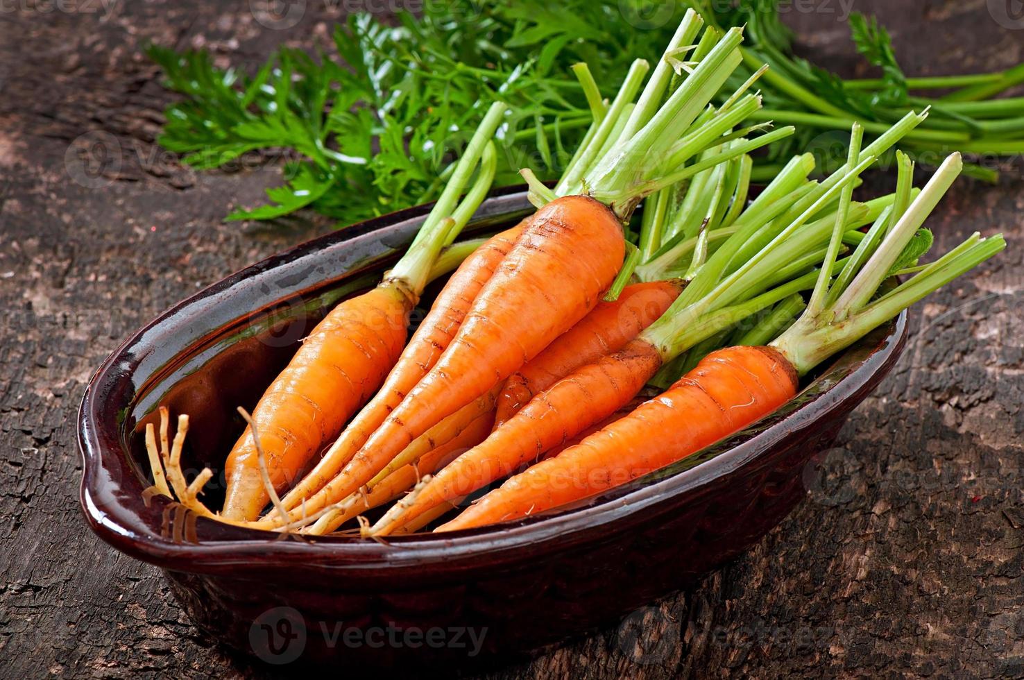 Fresh  carrots on old  wooden background photo