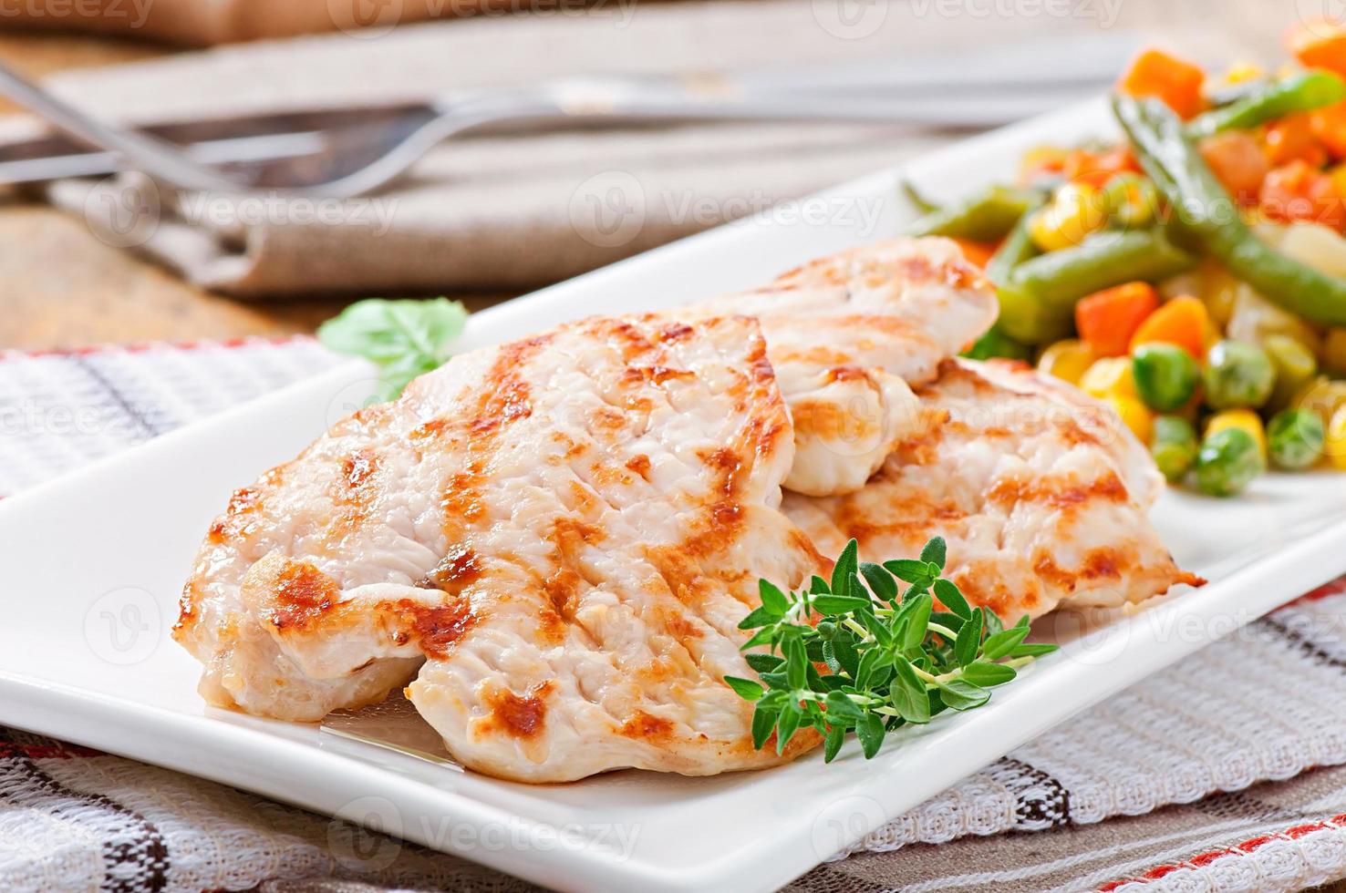 Grilled chicken breasts and vegetables photo