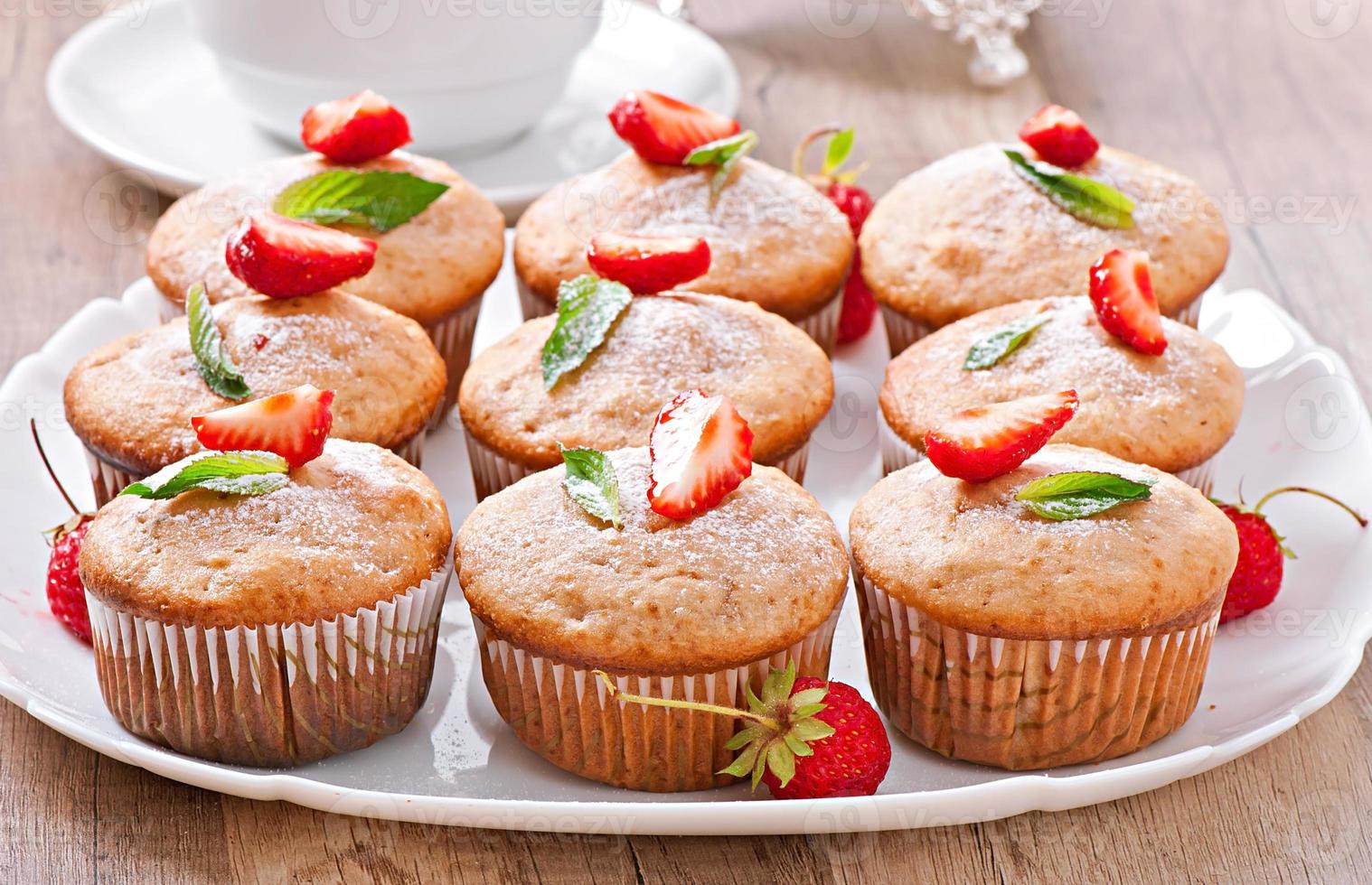 Strawberry muffin on a white plate with a fresh strawberry photo