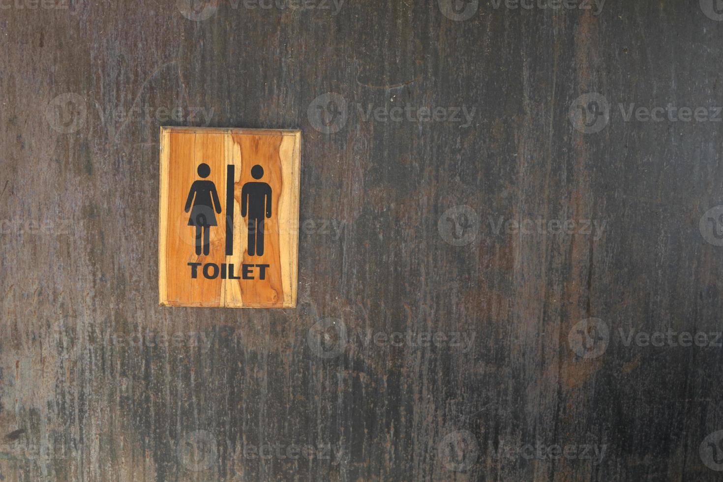 Toilet of man and woman sign on black wall. photo