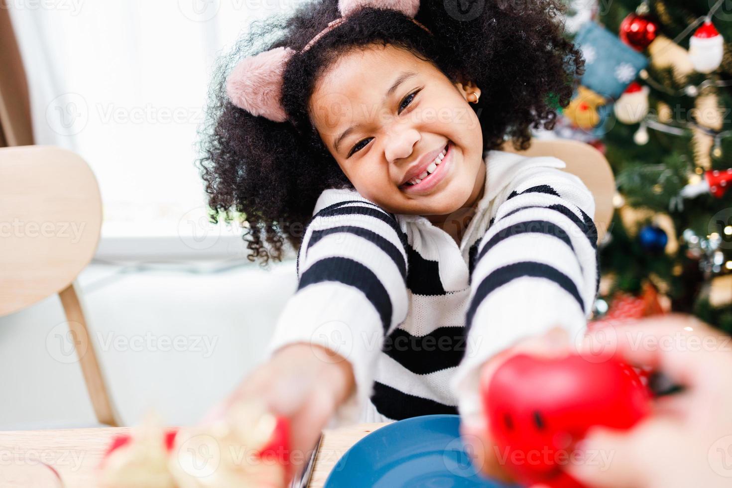 African American family surprising together with a gift on Christmas day while dinner. photo
